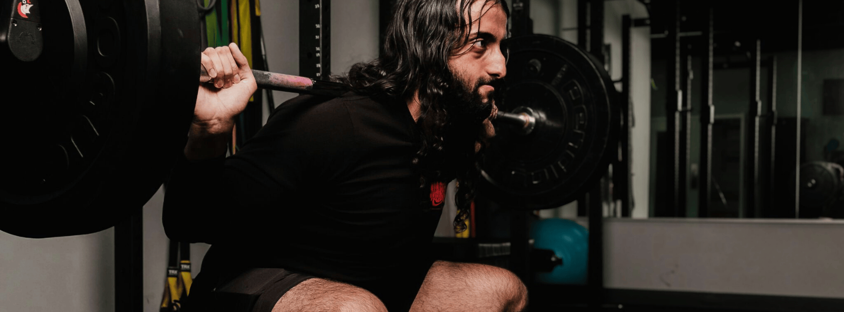 man doet squat in sport shirt